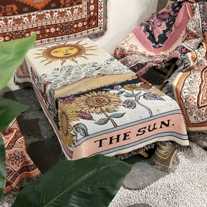 Detail of woven bohemian sun tarot blanket featuring sunflower patterns and fringe