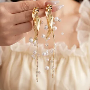 Elegant leaf earrings with pearls and long tassel fringe shown on a model