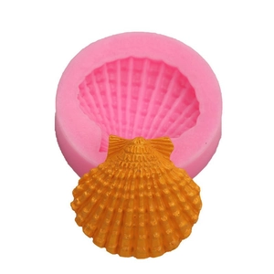 Roze siliconen mal met een gouden schelpencreatie voor taarten met oceaanthema