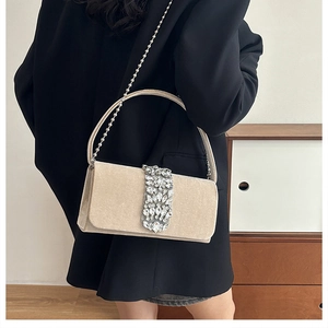 Detail of champagne velvet evening bag with crystal embellishment and metal chain