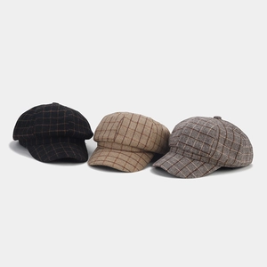 Detailed view of British style newsboy hats in three colors with plaid wool texture
