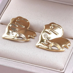 Close-up of gold geometric heart earrings with abstract texture in a leather jewelry box