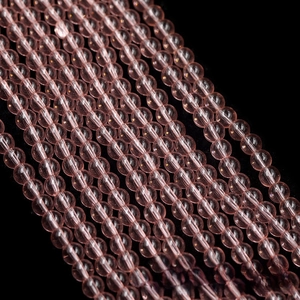 Macro view of translucent pink glass beads arranged in parallel rows for DIY jewelry
