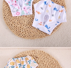 Detailed view of dog physiological pants with floral and cartoon prints on a woven mat