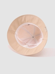 Detail showing the inner structure of a beige bucket hat with KUKUJI woven label