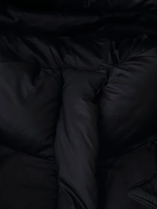 Detail view showing black padded jacket fabric texture and durable stitching work