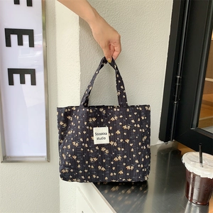 Detail of vintage floral canvas tote showing seersucker texture and brand label