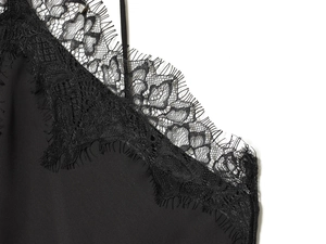 Close-up of delicate black eyelash lace trim on a silk halter neck evening dress