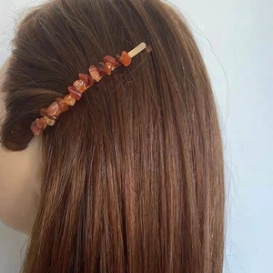 Elegant hair clip with natural reddish-brown crystal stones on a golden metal base