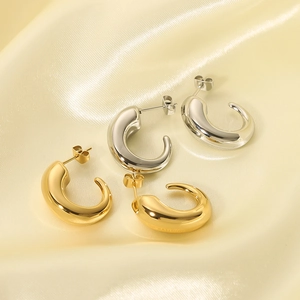 Polished C-shape hollow hoop earrings in gold and silver finish on silk fabric