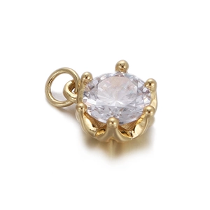Close-up of a gold-plated charm with a round zircon in a six-prong setting detail
