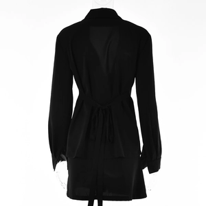 Detail view of black long-sleeved top with lace-up back design and matching mini skirt