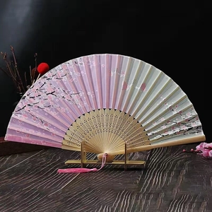 Detailed view of a Chinese folding fan with cherry blossom pattern and pink tassel
