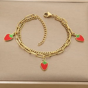 Detail of double-layer gold strawberry bracelet with paperclip and curb chain design