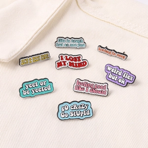 Detailed view of eight colorful inspirational quote enamel pins on white fabric collar