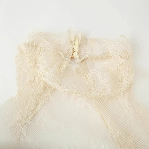 Robe en dentelle à manches évasées, détail de l'encolure en couleur crème beige