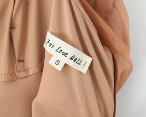 Détail de l'étiquette de cou du vêtement montrant la taille S et la marque For Love Bell