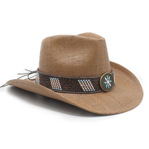 Detail of western straw hat with embossed leather band and vintage sunflower metal badge