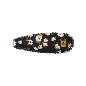 Détail d'une pince à cheveux BB fleurie avec marguerites blanches sur fond noir