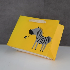 Yellow gift paper bag with cute cartoon zebra illustration and white ribbon handles