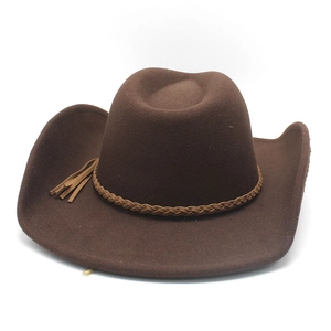 Détail d'un chapeau de cowboy en feutre marron foncé avec bande tressée et pompon