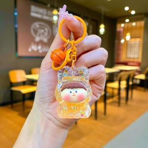Detailed close-up of a glowing bubble Lilith keychain with yellow glitter bear hood and bell