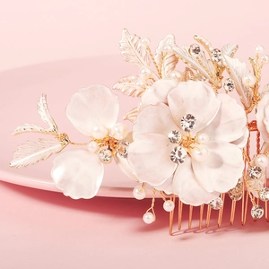 Detailed view of bridal hair comb with gold petals, pink flowers, pearls and rhinestones
