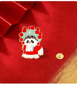 Macro shot of Peking Opera panda enamel pin with golden butterfly clutch on red background