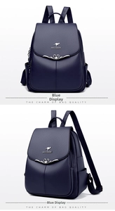 Detailed view of the dark blue pebbled leather backpack with a kangaroo logo and metal heart