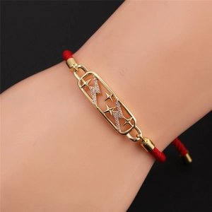 Dettaglio del bracciale rosso intrecciato con placca stella e fulmine e zirconi