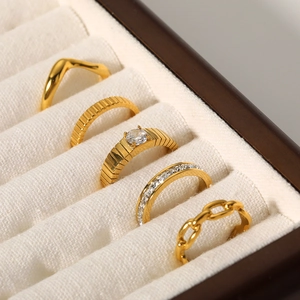 5-piece set of 18K gold plated titanium steel rings with wave and chain designs in a box