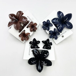 Detail of frangipani hair claw clip set in brown, dark blue, and black resin finish