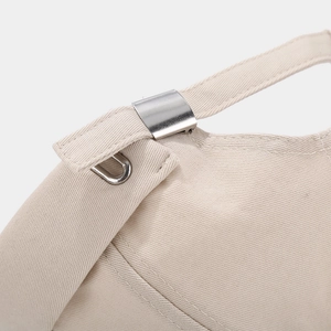 Detail of adjustable metal buckle and stitching on a beige cotton brimless docker hat