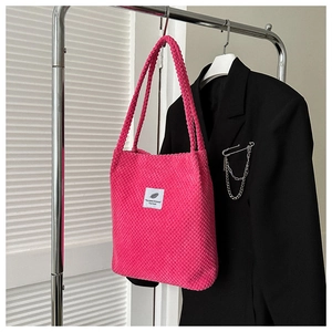 Detailed shot of hot pink popcorn textured tote bag featuring a white square fabric label