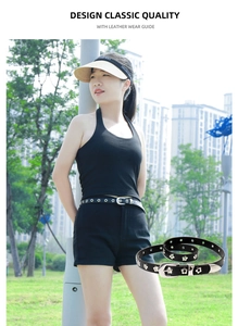 Detail of black leather belt with silver floral rivets and polished alloy buckle