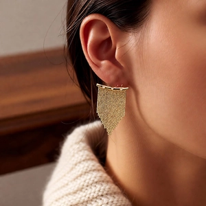 Gros plan de boucles d'oreilles pompons plaquées or 14K avec maille en zircon sur modèle