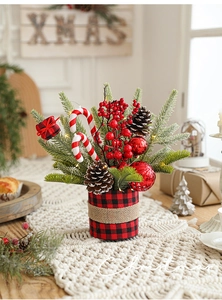 Close-up of Christmas centerpiece with faux pine twigs, red berries, and pine cones