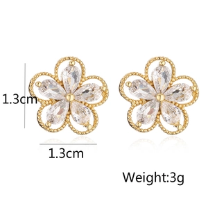 Macro shot of gold floral stud earrings with white cubic zirconia measuring 1.3cm x 1.3cm