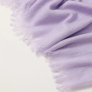 Detail of lavender cotton linen scarf featuring soft woven texture and fringe edges
