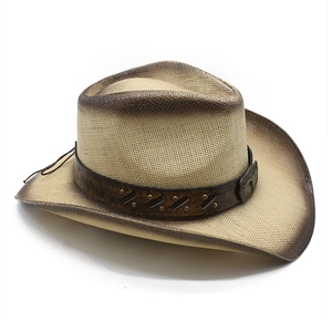 Gros plan d'un chapeau de cowboy en paille avec bande en cuir vieilli et rivets