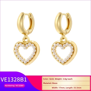 Detailed view of gold brass heart earrings with small pearls measuring 17mm by 33.5mm