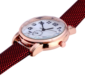 Macro detail of rose gold watch case with unique scalloped edge and white numeric dial