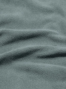 Vista macro che mostra la consistenza morbida e i dettagli del tessuto pile grigio-blu