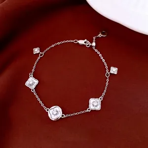 Bracelet fleuri élégant plaqué or 18 carats avec zircons et nacre sur velours rouge chic