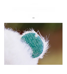 Macro shot of green plush Christmas tree ornament showing soft faux fur top detail