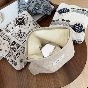 Detail view of linen small makeup bags with ethnic embroidery and zipper closure