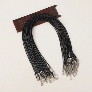 Detail of black wax cord necklaces with silver lobster clasps and extension chains on wood