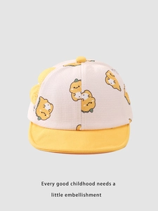 Detailed close-up of a cotton baby baseball cap featuring a yellow dinosaur cartoon pattern