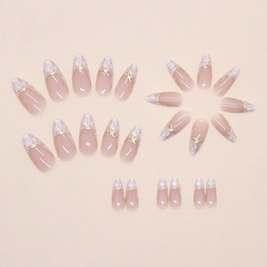 Close-up of almond press-on nails featuring marble French tips and gold 3D bow details