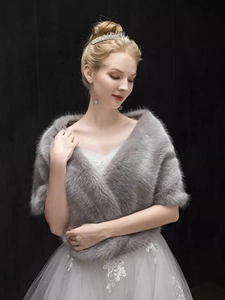Detail of elegant grey faux fur bridal shawl wrap worn over a white wedding dress